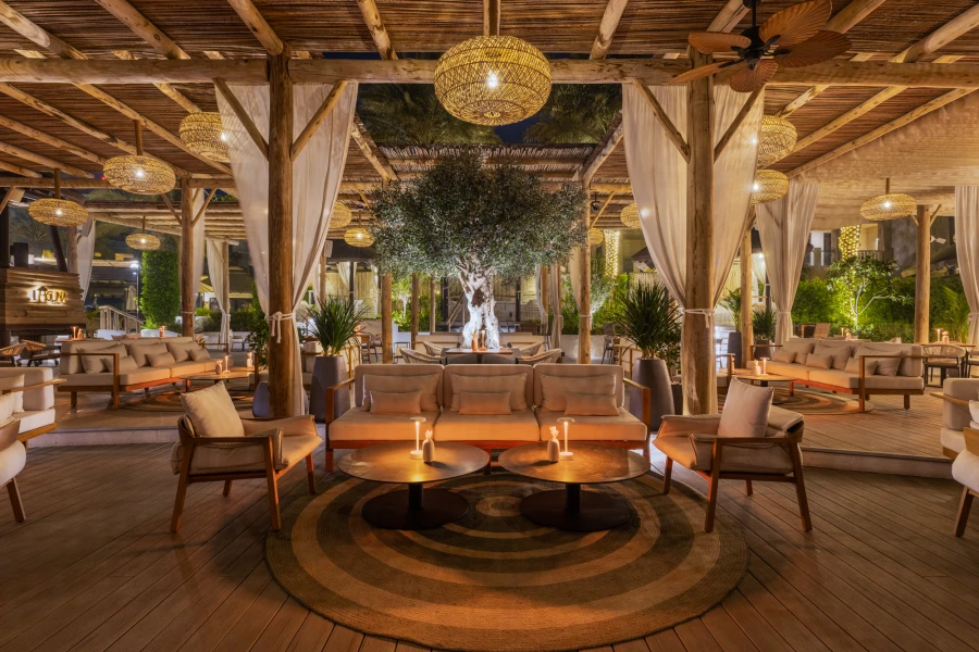 Boho-inspired outdoor bar with exterior artificial olive tree creating a relaxed Mediterranean atmosphere