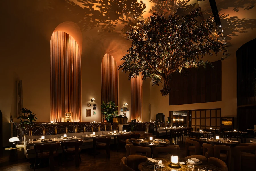 Artificial tree suspended from restaurant ceiling in dark and atmospheric restaurant interior